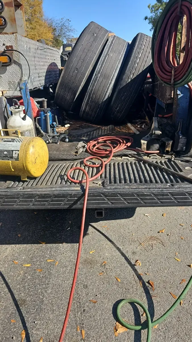 Fully equipped J&L Gonzalez truck bed with commercial tires, air compressor, and hoses ready for mobile service