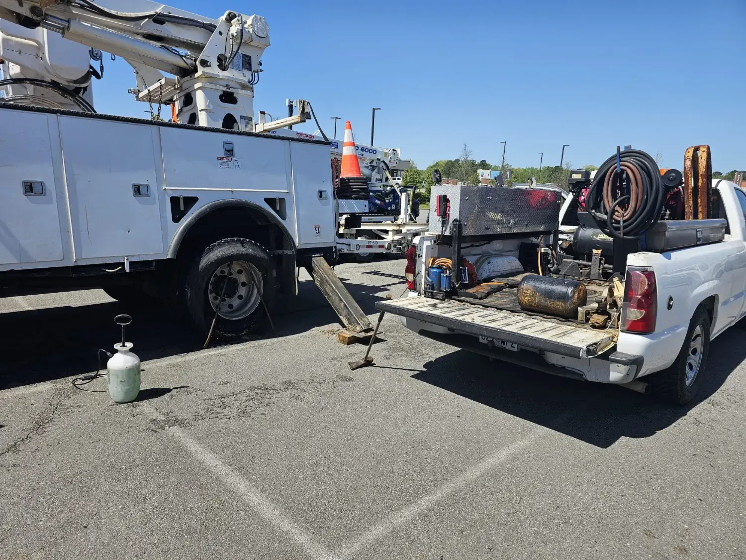 J&L Gonzalez mobile tire service truck assisting a utility vehicle with tire change in parking lot