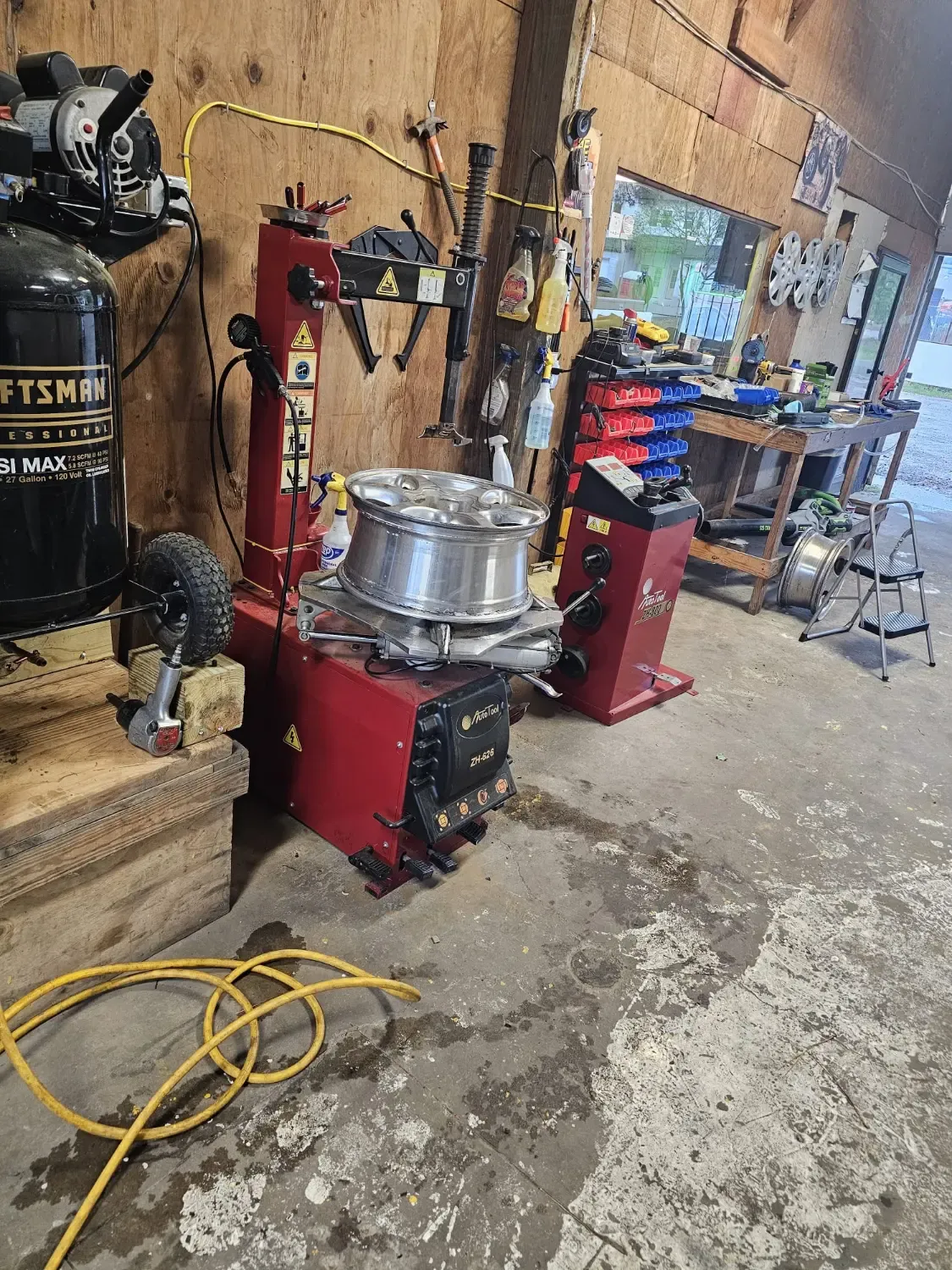 Professional tire changer and balancer machines with Craftsman compressor at J&L Gonzalez workshop
