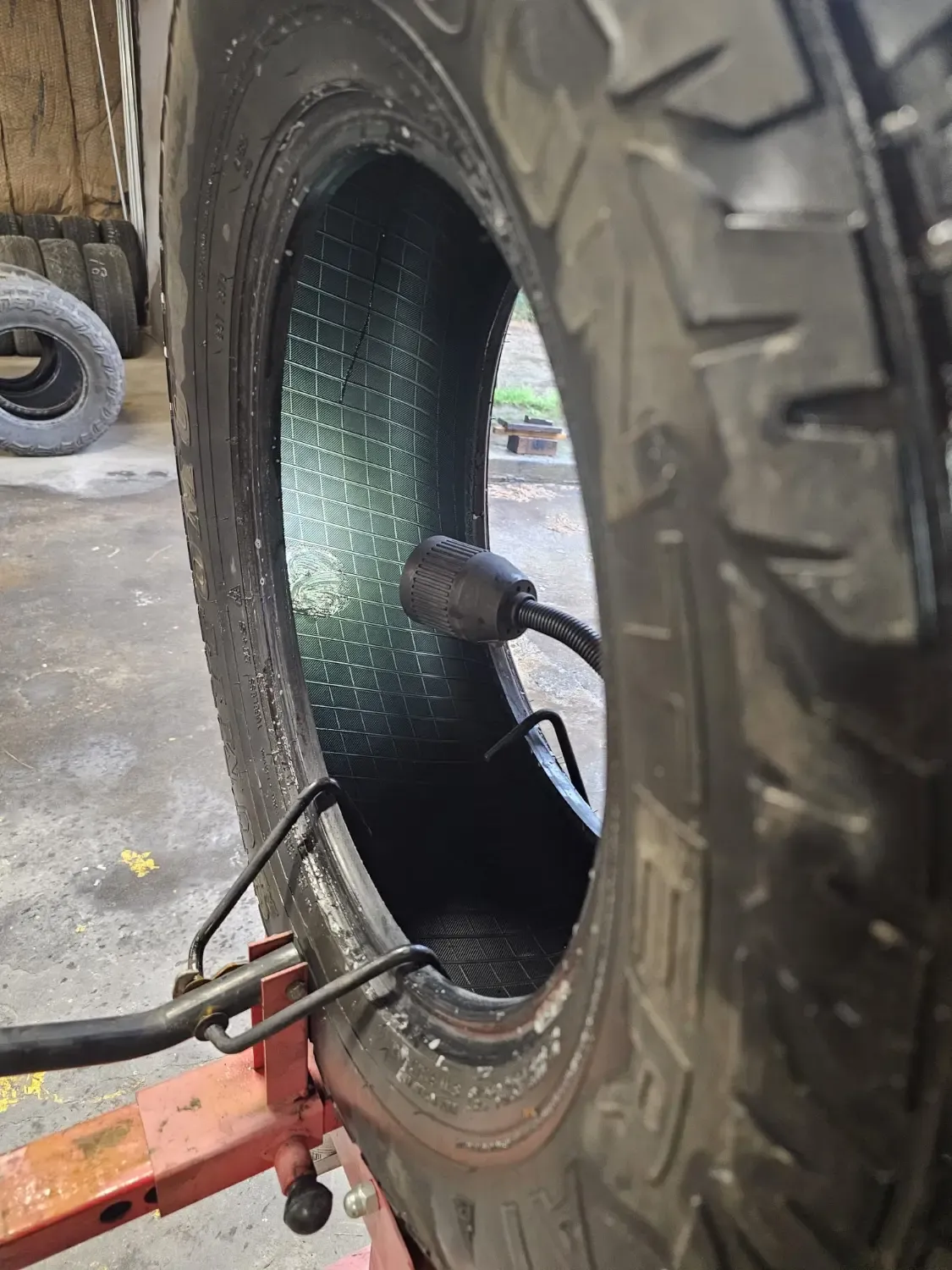 Close-up inspection of heavy-duty truck tire valve stem during mobile repair service