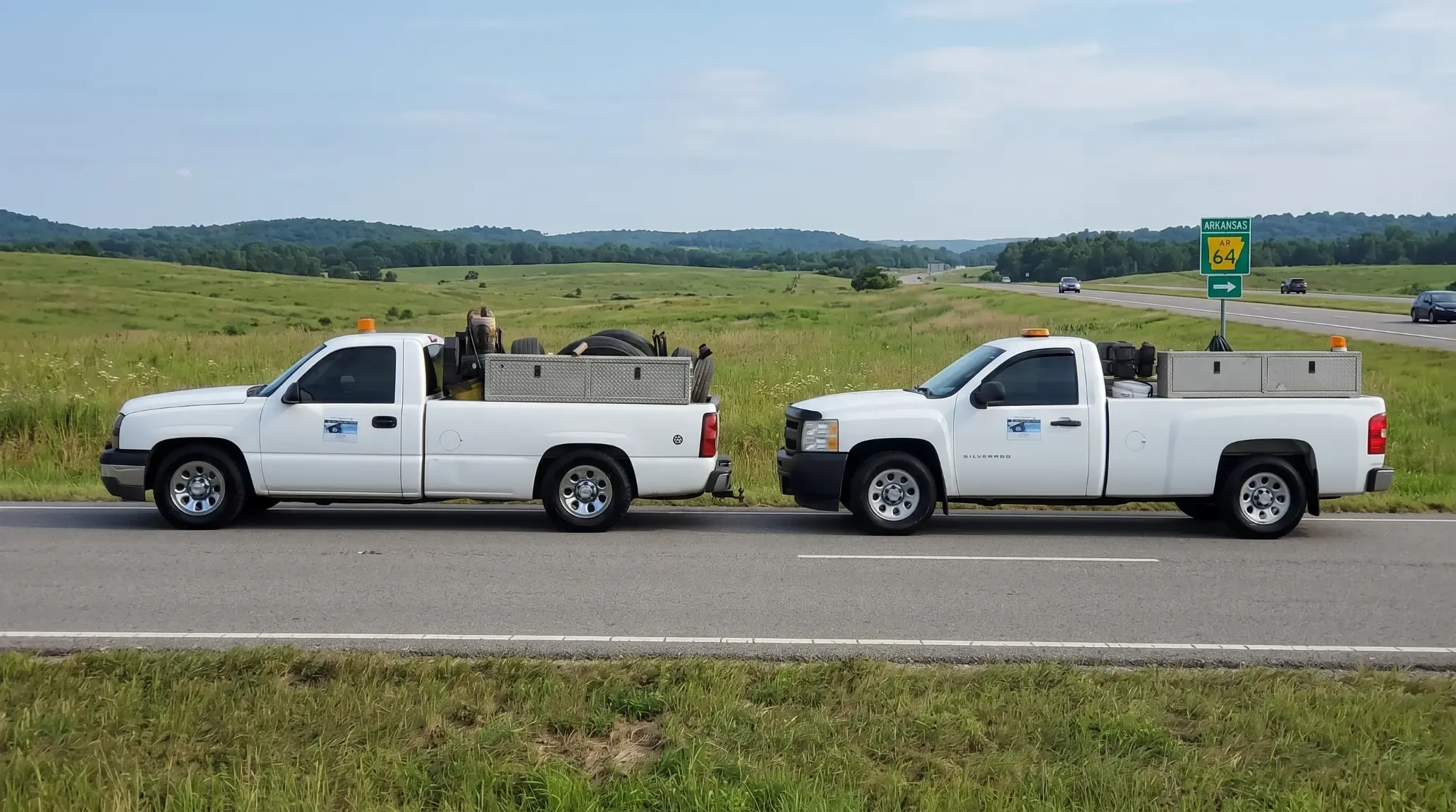 Two fully equipped J&L Gonzalez mobile tire service trucks parked on Arkansas Highway 64