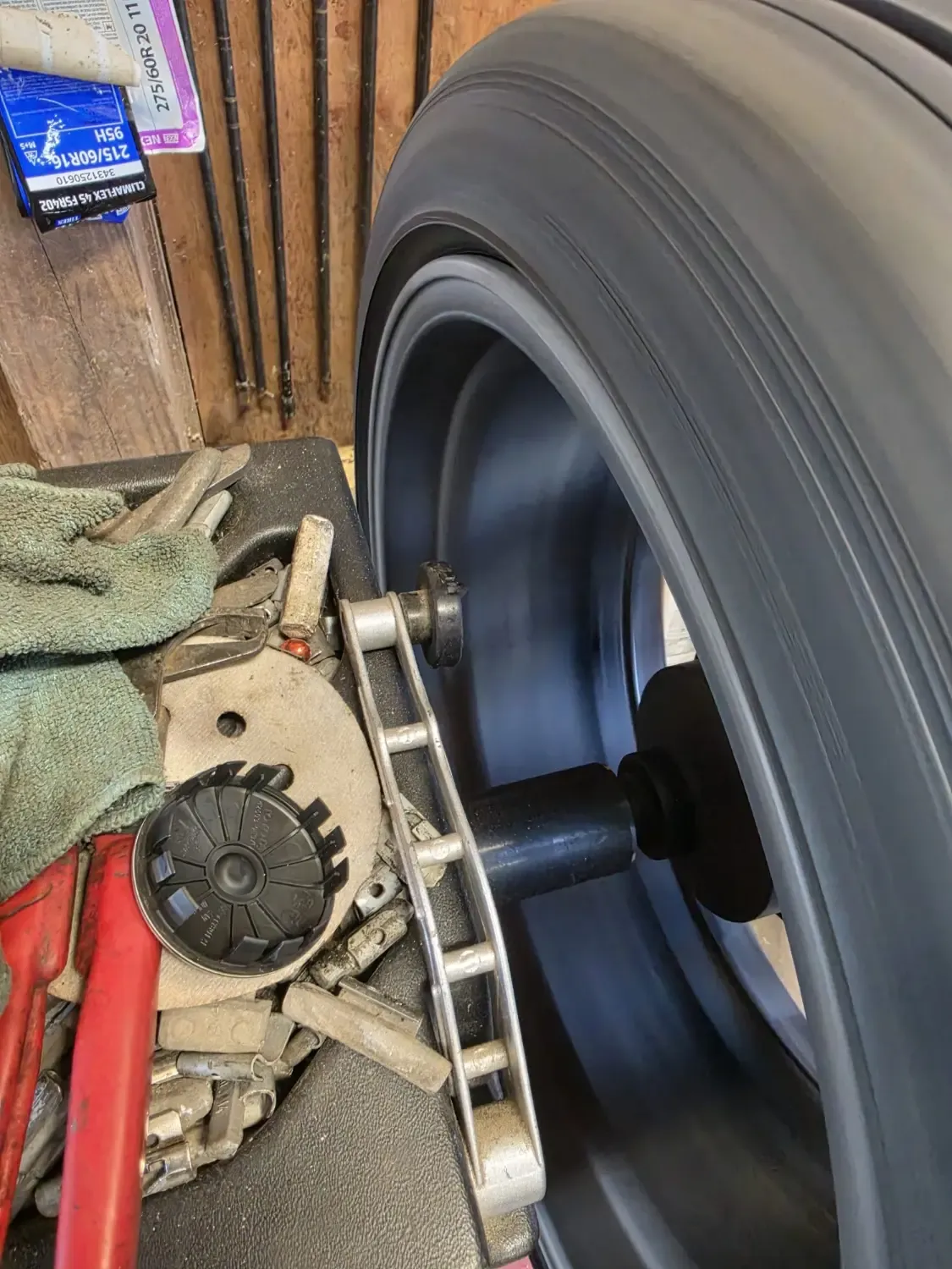 Close-up of new tire mounted on balancing machine with wheel weights at J&L Gonzalez tire workshop