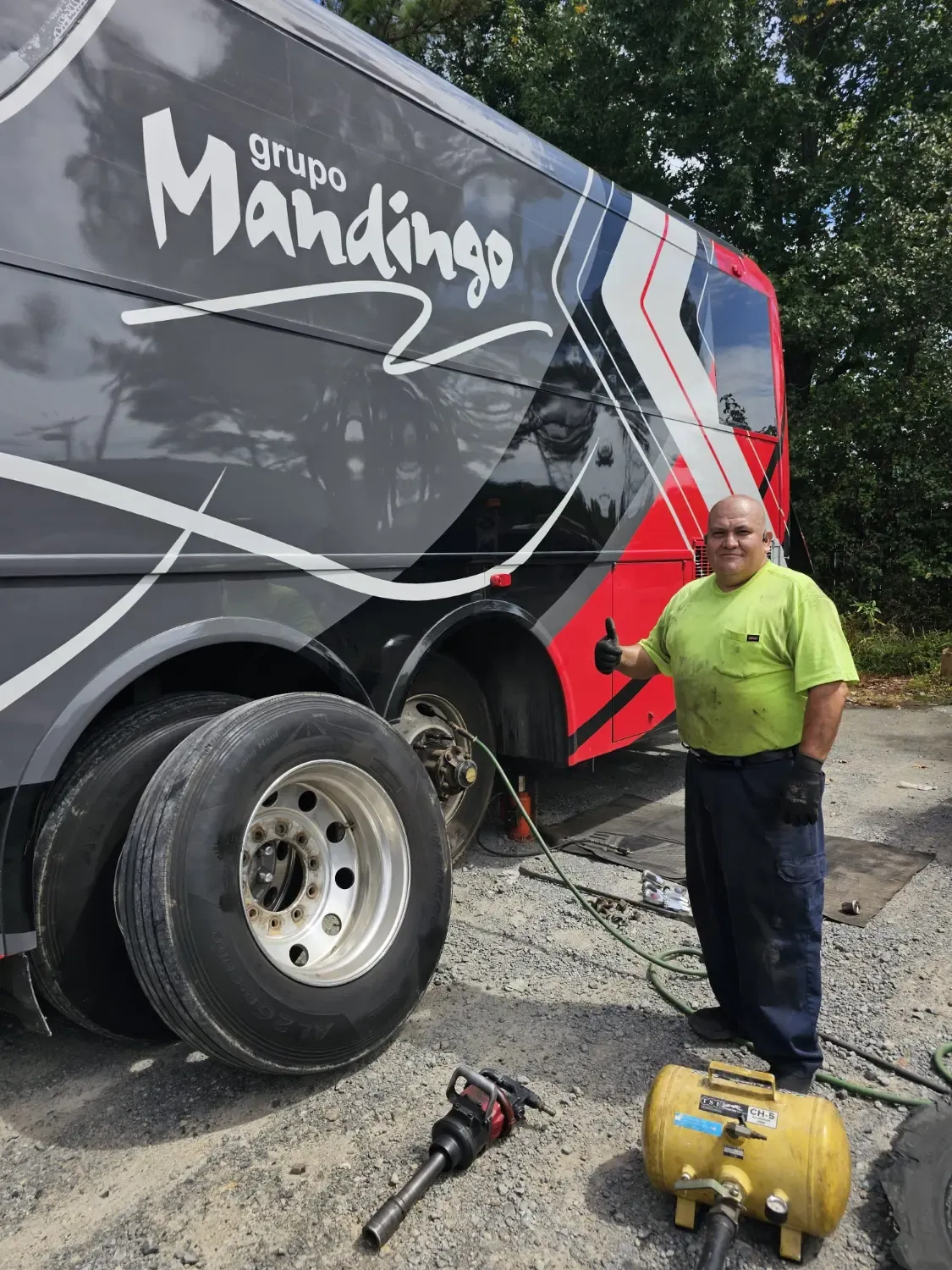J&L Gonzalez technician giving thumbs up after completing tour bus tire change in Arkansas
